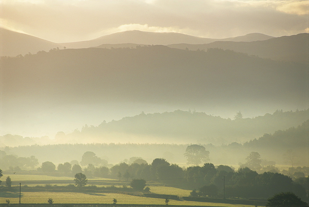 View of hills and landscape in early morning mist, River Derwent Valley, Lake District, Cumbria, England, United Kingdom, Europe