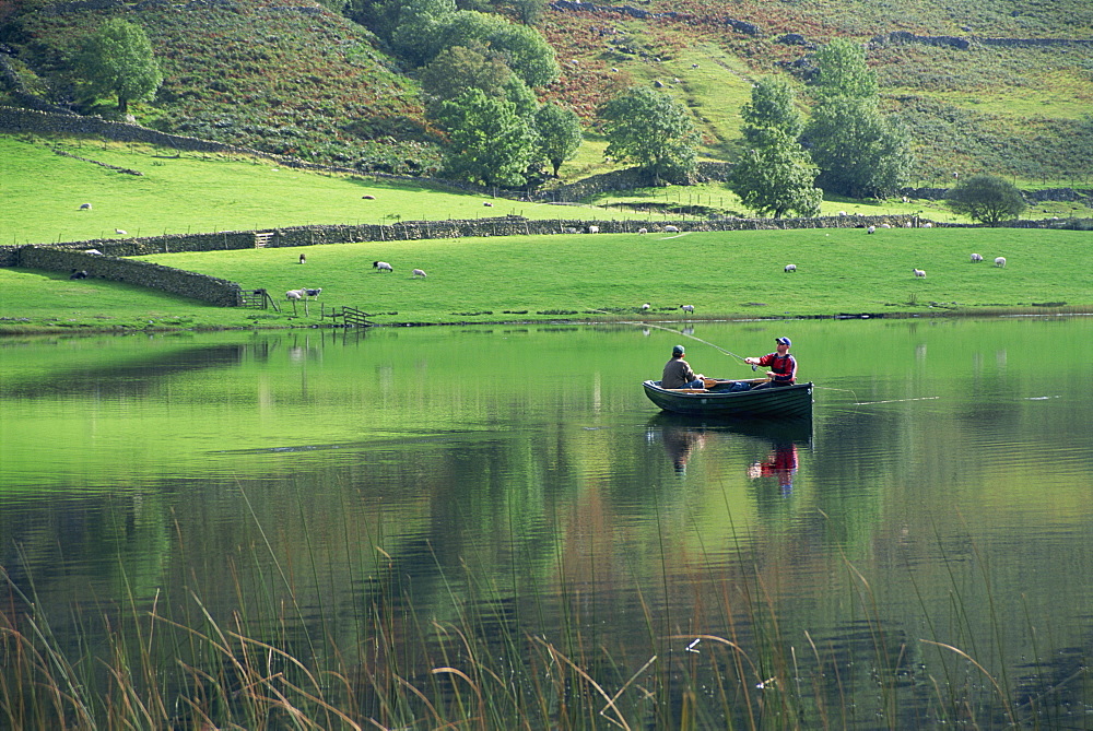 Tranquil scene of two men in a boat on a lake, fly fishing, Watendlath Tarn, Lake District National Park, Cumbria, England, United Kingdom, Europe