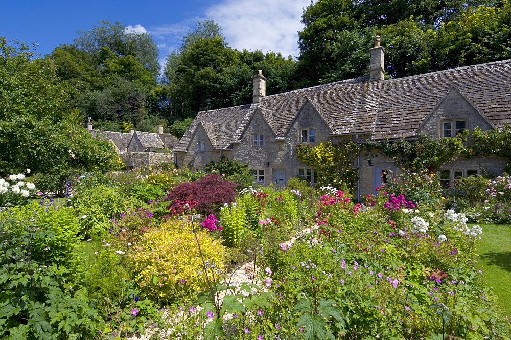 Traditional Cotswold stone cottages with colourful flower gardens, Bibury, Gloucestershire, Cotswolds, England, United Kingdom, Europe