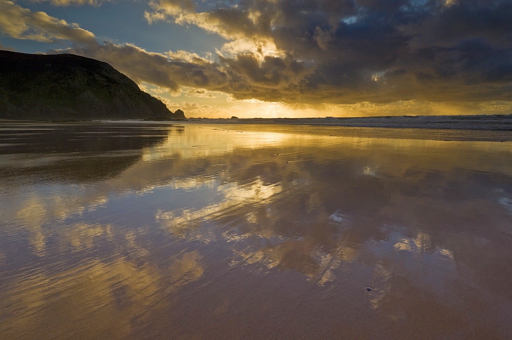 Sunset reflected in tidal wash, Praia do Castelejo beach near Vila do Bispo, Algarve, Portugal, Europe