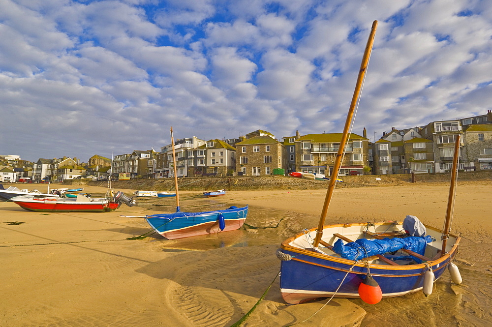 Strange cloud formation in the early morning with small Cornish fishing boats at low tide in the harbour at St. Ives, Cornwall, England, United Kingdom, Europe