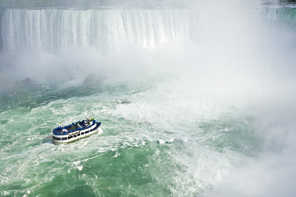 Maid of the Mist tour excursion boat under the Horseshoe Falls waterfall at Niagara Falls, Ontario, Canada, North America