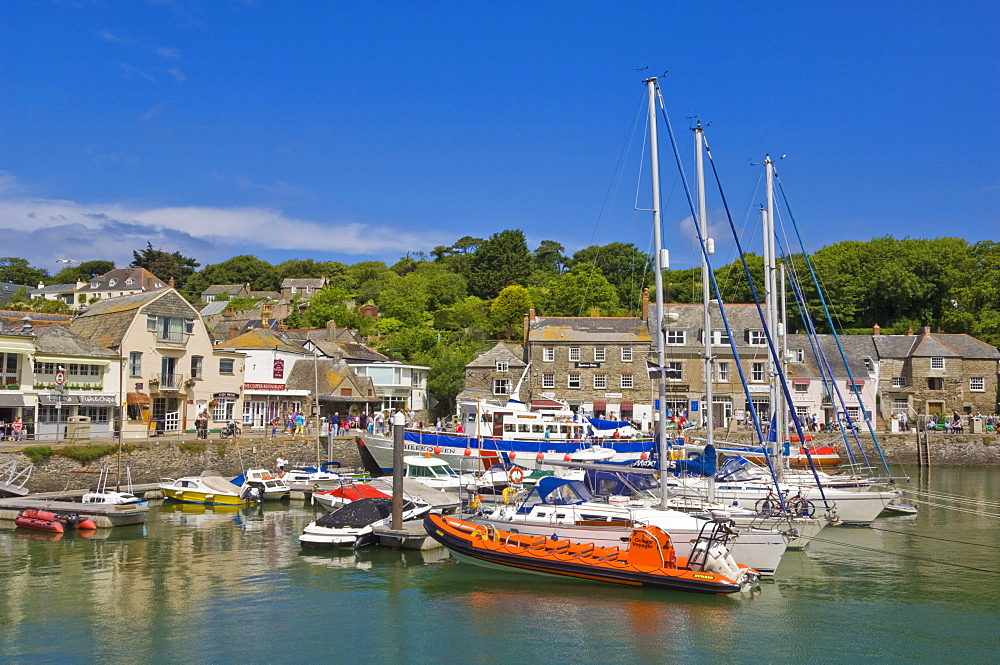 Busy tourist shops, small boats and yachts at high tide in Padstow harbour, Padstow, North Cornwall, England, United Kingdom, Europe