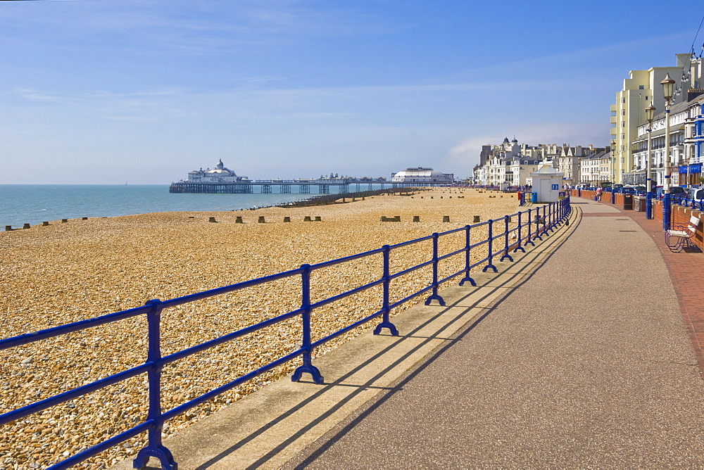 Pebble beach and groynes, hotels on the seafront promenade, Eastbourne pier in the distance, Eastbourne, East Sussex, England, United Kingdom, Europe