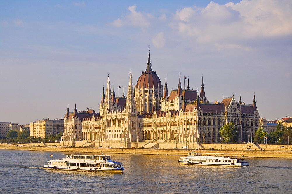 The neo-gothic Hungarian Parliament building, designed by Imre Steindl, UNESCO World Heritage Site, with cruise boats on the River Danube in the foreground, Budapest, Hungary, Europe