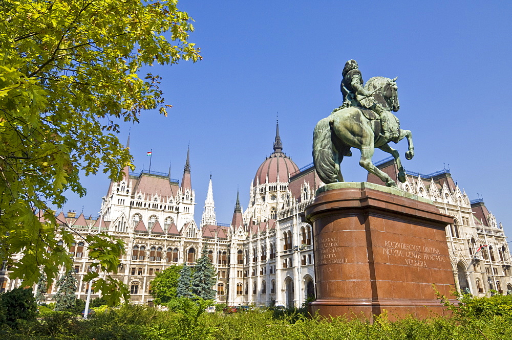 The neo-gothic Hungarian Parliament building front entrance, designed by Imre Steindl, with an equestrian statue of Ferenc Rakoczi II in foreground, Budapest, Hungary, Europe