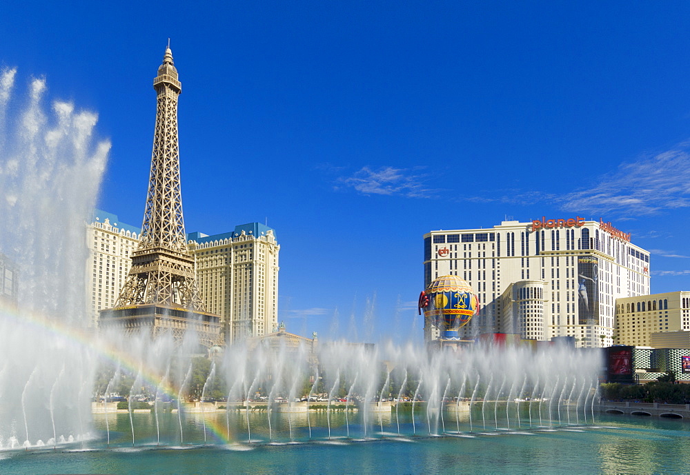 Rainbow produced by the dancing water fountains of the Bellagio hotel with Planet Hollywood hotel, and Paris Hotel with the Eiffel tower, The Strip, Las Vegas Boulevard South, Las Vegas, Nevada, United States of America, North America