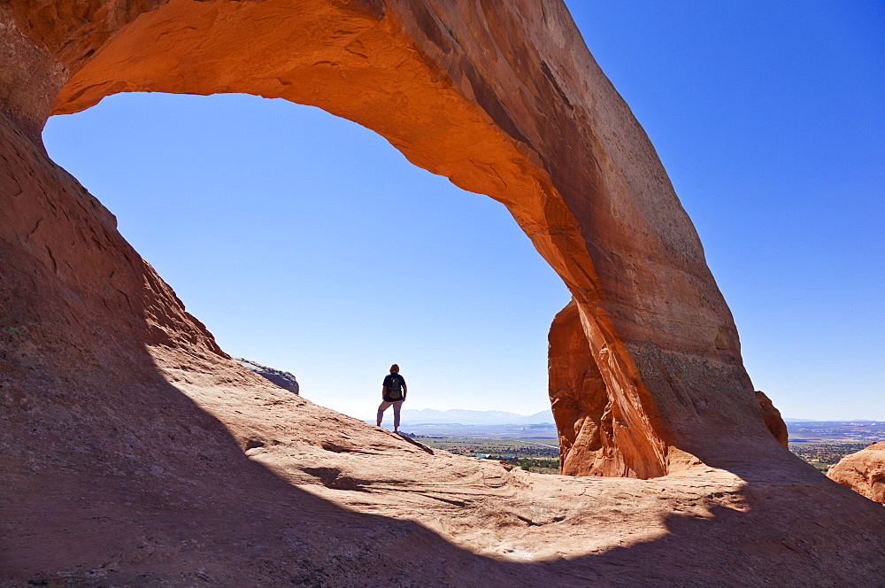 Lone tourist hiker at Wilson Arch, near Moab, Utah, United States of America, North America 