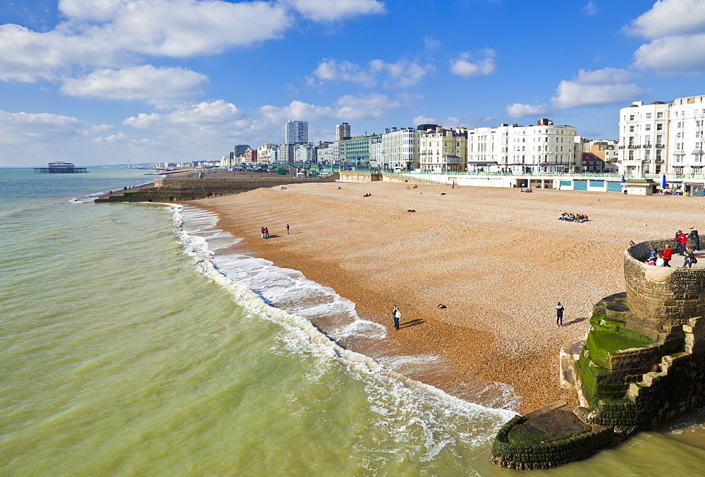 The seafront with people on the beach at Brighton Beach, East Sussex, England, United Kingdom, Europe