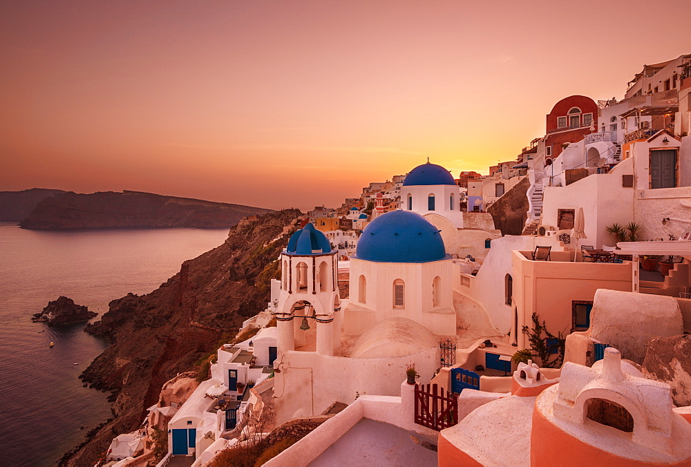 Greek church with three blue domes at sunset, Oia, Santorini (Thira), Cyclades Islands, Greek Islands, Greece, Europe