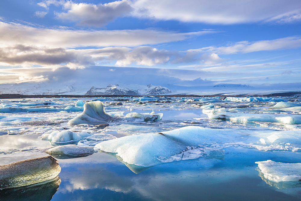 Mountains behind icebergs locked in the frozen water of Jokulsarlon Lagoon, Jokulsarlon, southeast Iceland, Iceland, Polar Regions