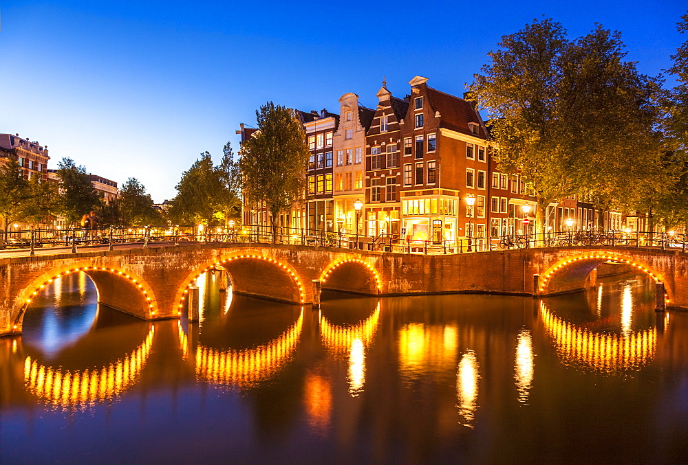 Illuminated bridges and reflections at night, Keizergracht and Leilesgracht canals, Amsterdam, North Holland, Netherlands, Europe