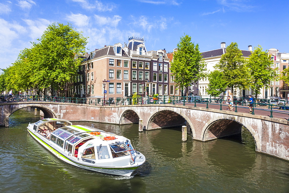 Canal tour boat and bridges at the junction of Leidsegracht Canal and Keizergracht Canal, Amsterdam, North Holland, Netherlands, Europe