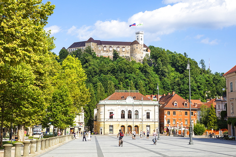 Ljubljana Castle with Slovenian flag behind the Slovenian Philharmonic building, Congress Square, Ljubljana, Slovenia Europe