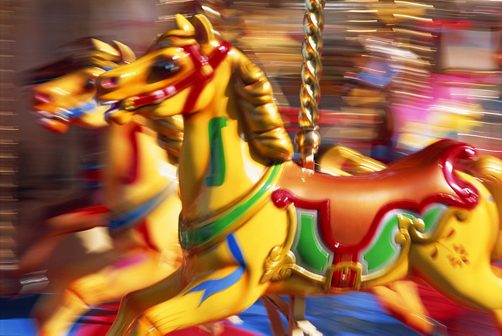 Motion blur of brightly painted merry go round (carousel) horses at speed, Skegness, Lincolnshire, England, United Kingdom, Europe