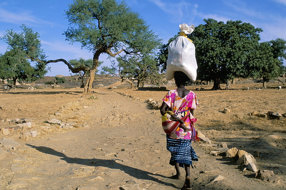 Woman carrying sack on her head, Ogol village, Sangha, Dogon area, Mali, Africa