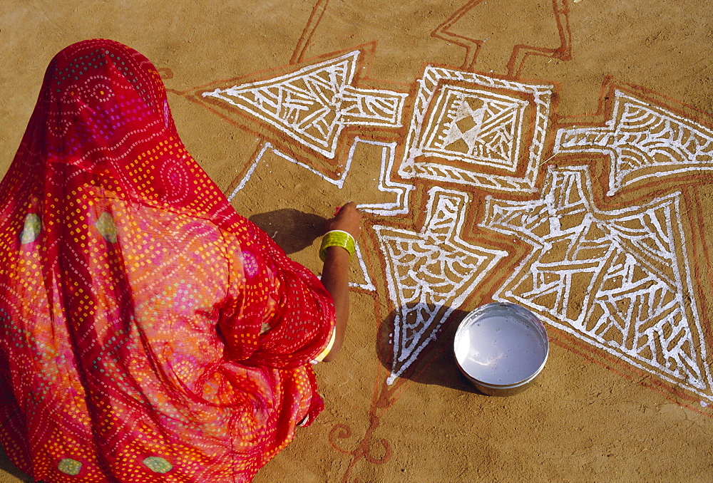 Woman painting a Mandala design on the ground, near Jodhpur, Rajasthan, India"Mandalas are symbolic diagrams used in Hindu and Buddhist Tantrism and meditation, A mandala is basically a representation of the Universe"