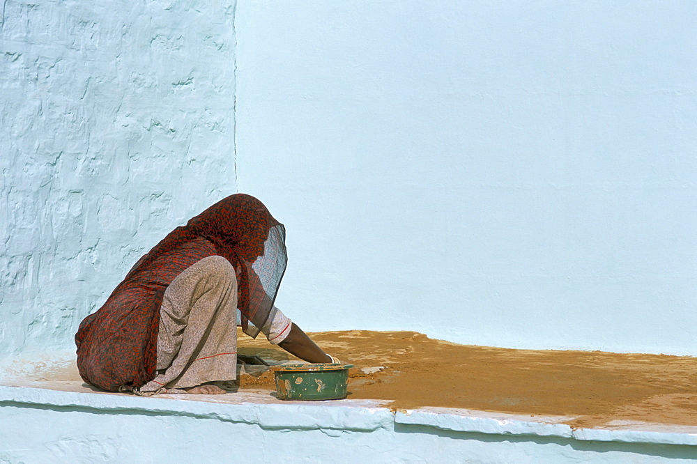 Woman painting walls in a village in the Barmer area, Rajasthan state, India, Asia