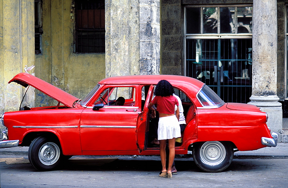 Young woman, American red car, Havana, Cuba, Central America