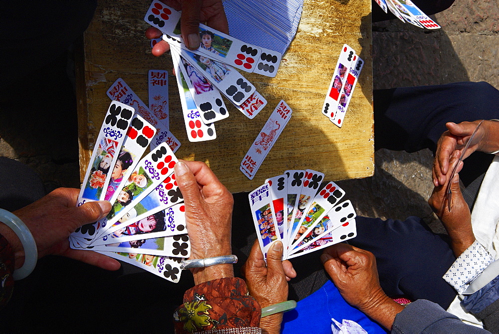 Naxi women playing a local game of cards, Lijiang, Yunnan, China, Asia 