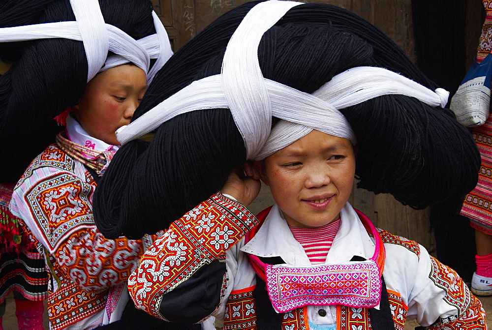 Long Horn Miao girls in traditional costumes celebrating Flower Dance Festival, Longjia village, Guizhou Province, China, Asia