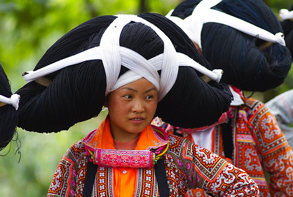 Long Horn Miao girls in traditional costumes celebrating Flower Dance Festival, Longjia village, Guizhou Province, China, Asia