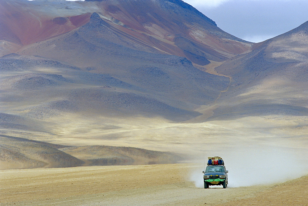 4 wheel drive car driving through a colourful volcanic landscape near las rocas de Dali, Los Lipez, Southwestern Bolivia 