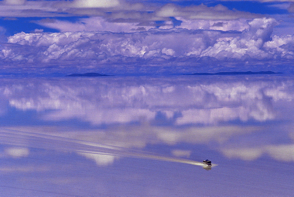 Bus driving through the ethereal landscape of the Salar de Uyuni, Salar de Uyuni salt lake, Bolivia, South America