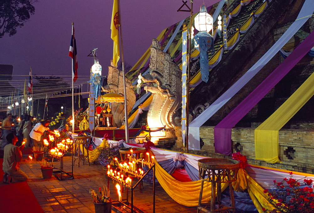 People worshipping during Buddhist festival at the foot of temple chedi, Wat Chedi Luang, Chiang Mai, Thailand, Southeast Asia, Asia