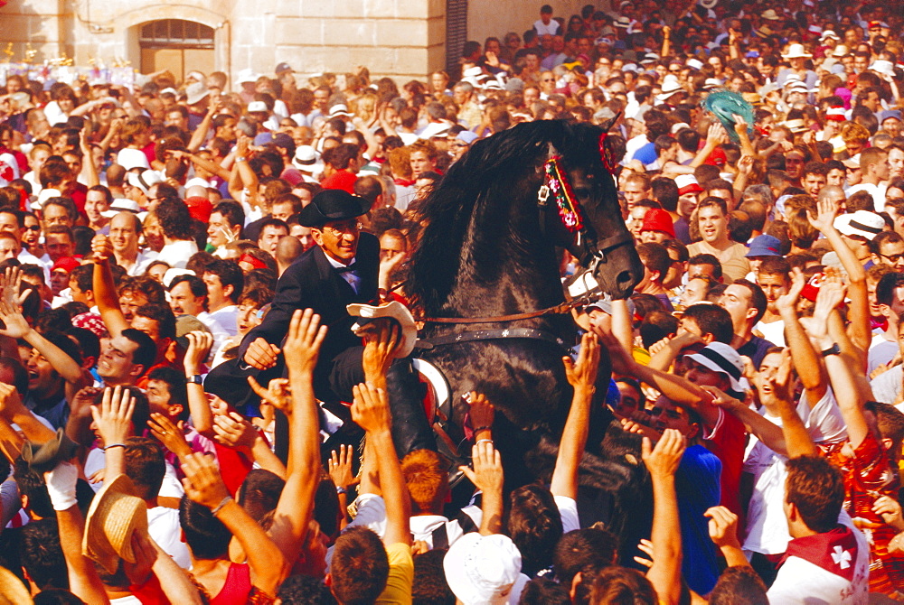 Rider on a rearing horse among the crowds during Sant Joans festival, Ciutadella, Minorca, Spain