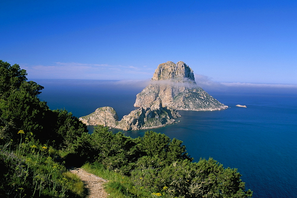 The rocky islet of Es Vedra surrounded by mist, with pine trees in foreground, near Sant Antoni, Ibiza, Balearic Islands, Spain, Mediterranean, Europe