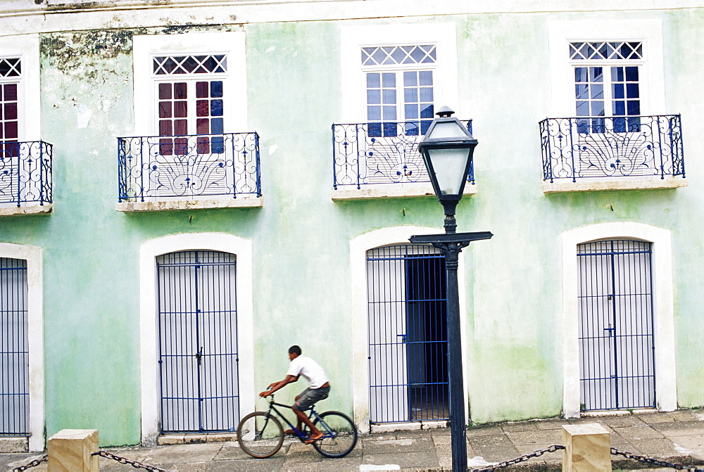 Man riding bicycle in front of old colonial house, Sao Luis, Maranhao, Brazil, South America