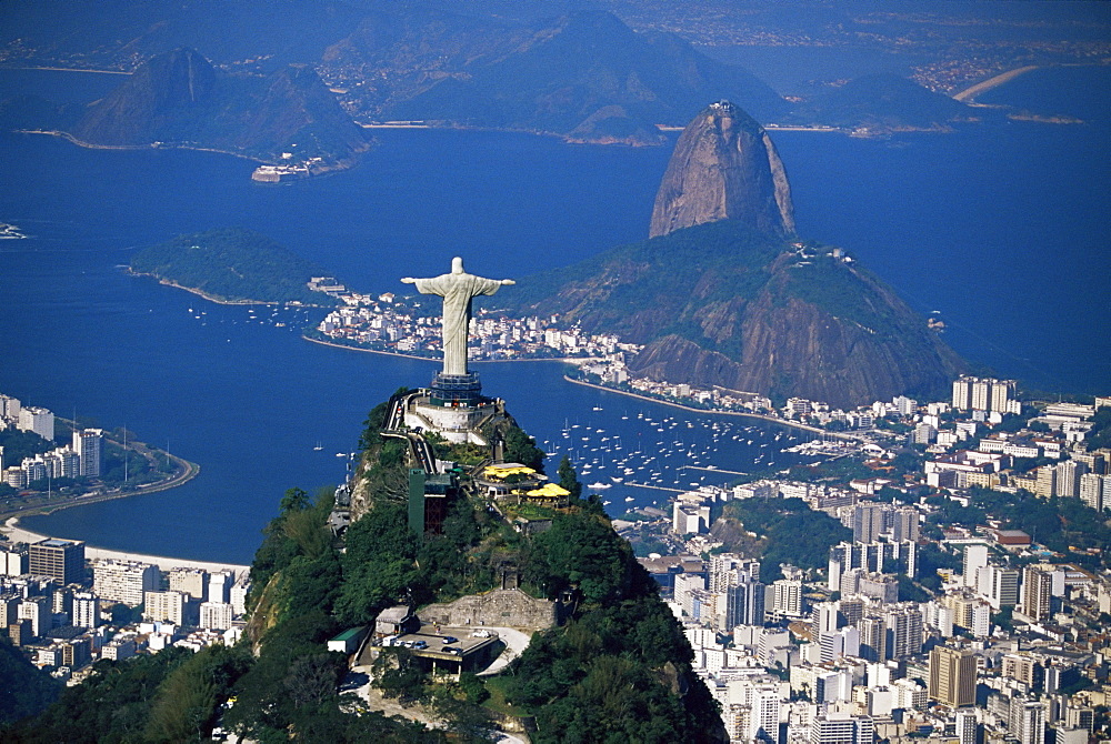 Aerial view of city with the Cristo Redentor (Christ the Redeemer) statue in foreground and Pao de Acucar (Sugar Loaf) in the background, Rio de Janeiro, Brazil, South America