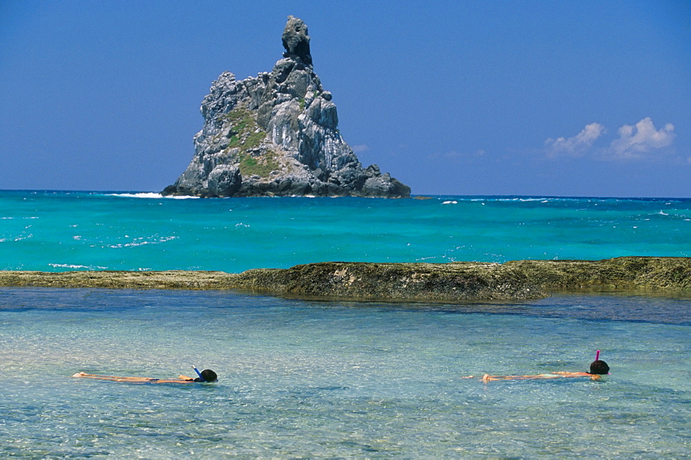 People snorkelling at Praia da Atalaia inside natural swimming pools, Parque Nacional de Fernando de Norohna, Fernando de Noronha, Pernambuco, Brazil, South America