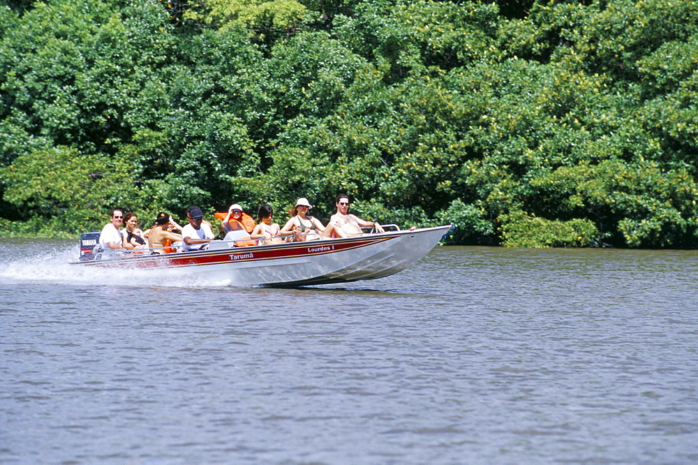 Tourists in speed boat riding on Rio Preguica, Parque Nacional dos Lencois Maranhenses, Barreirinhas, Lencois Maranhenses, Brazil, South America