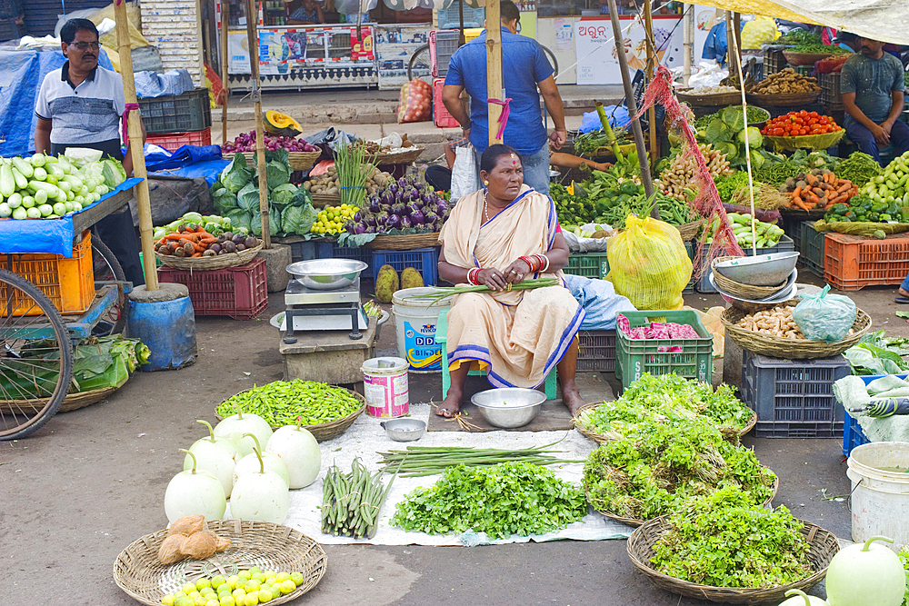 A fruit and vegetable seller and her wares in the centre of Puri near the twelth century Jagannath Temple, Puri, Odisha, India, Asia