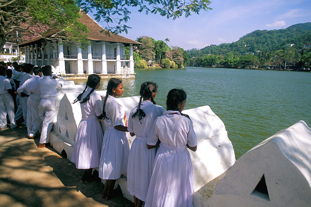 Girls standing on the edge of the artificial lake, Kandy, Sri Lanka, Asia