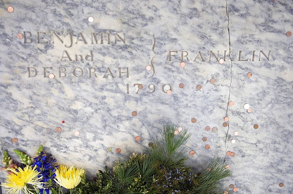 Visitors throw a penny on Benjamin Franklin's grave at Christ Church burial ground during celebrations for Benjamin Franklin' s 300th birthday, Philadelphia, Pennsylvania, United States of America, North America