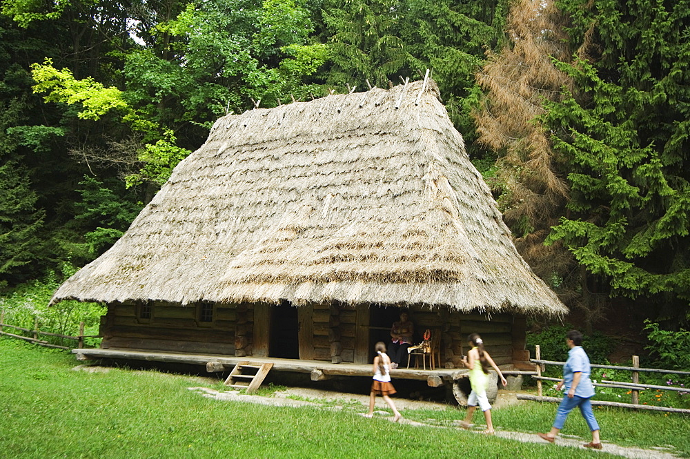 Tourists visiting traditional thatched roof house in the Museum of Folk Architecture and Rural Life, Old Town, UNESCO World Heritage Site, Lviv, Ukraine, Europe