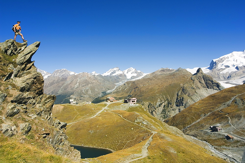 Hiker on trail above lake at Schwarzee Paradise, Zermatt Alpine Resort, The Valais, Swiss Alps, Switzerland, Europe