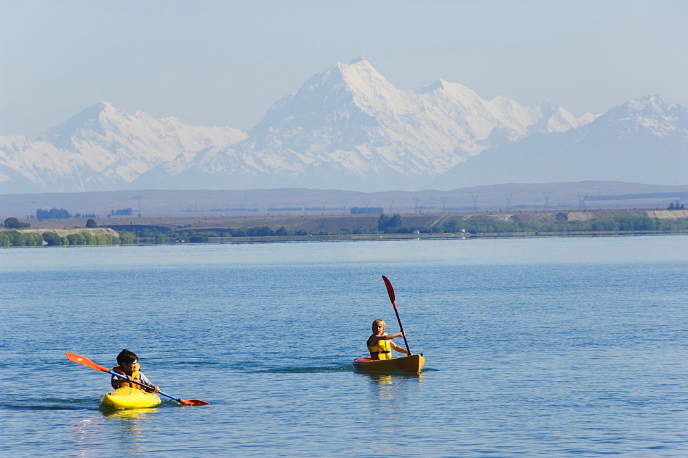 Kayaking on Lake Benmore and a distant Aoraki (Mount Cook), 3754m, Australasia's highest mountain, Southern Alps, Mackenzie Country, Otago, South Island, New Zealand, Pacific