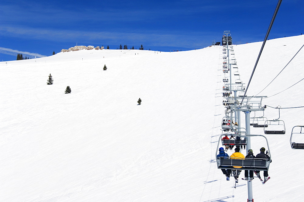 Skiers being carried on a chair lift to the back bowls of Vail ski resort, Vail, Colorado, United States of America, North America