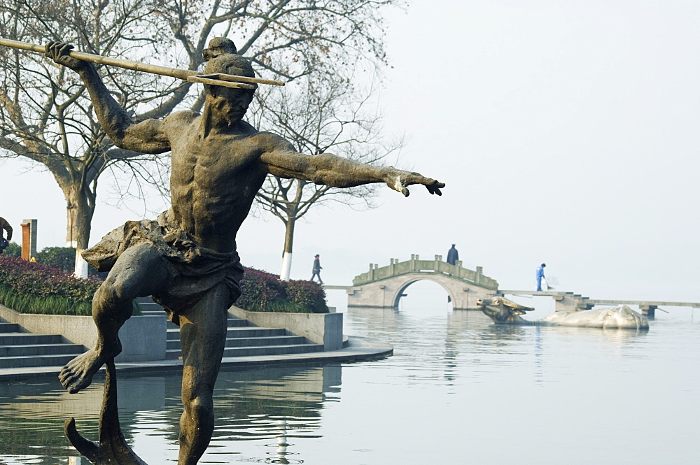 Statue of a spear fisherman in the waters of West Lake, Hangzhou, Zhejiang Province, China, Asia