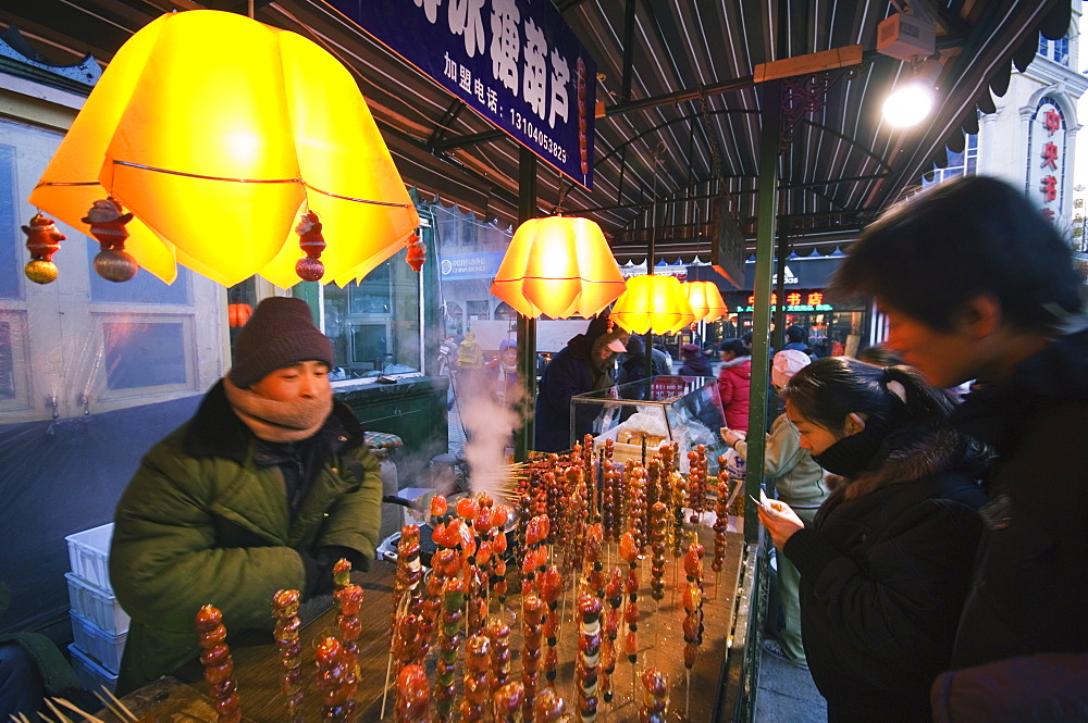 A street market selling local snacks and sweet hawthorne on sticks, Daoliqu area, Harbin, Heilongjiang Province, Northeast China, China, Asia