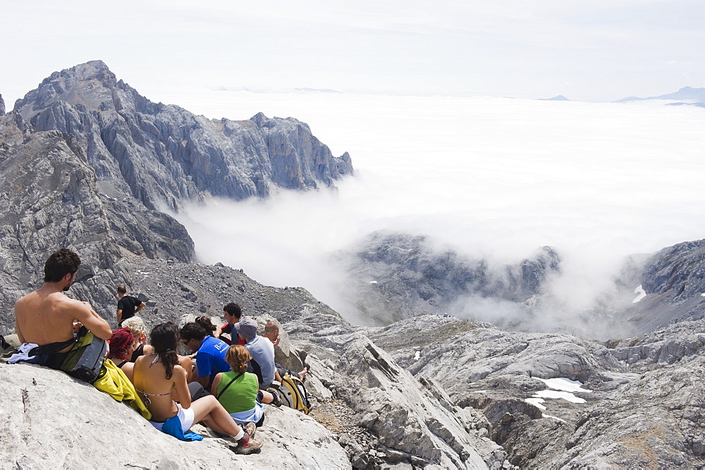 Hikers taking a break on Tesorero Peak, in Picos de Europa National Park, shared by the provinces of Asturias, Cantabria and Leon, Spain, Europe