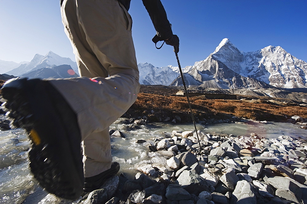 Trekker crossing a mountain stream, Ama Dablam, 6812m, Solu Khumbu Everest Region, Sagarmatha National Park, Himalayas, Nepal, Asia