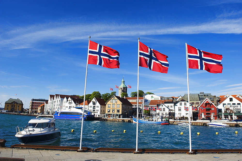 Norwegian flags and historic harbour warehouses, Stavanger, Norway, Scandinavia, Europe