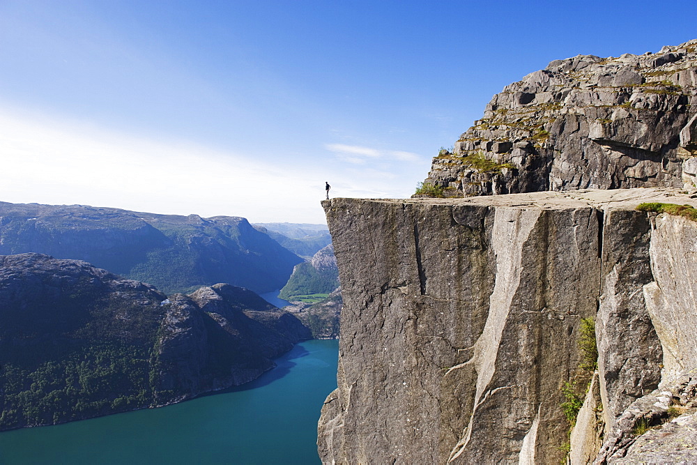 Man standing on Preikestolen (Pulpit Rock) above fjord, Lysefjord, Norway, Scandinavia, Europe