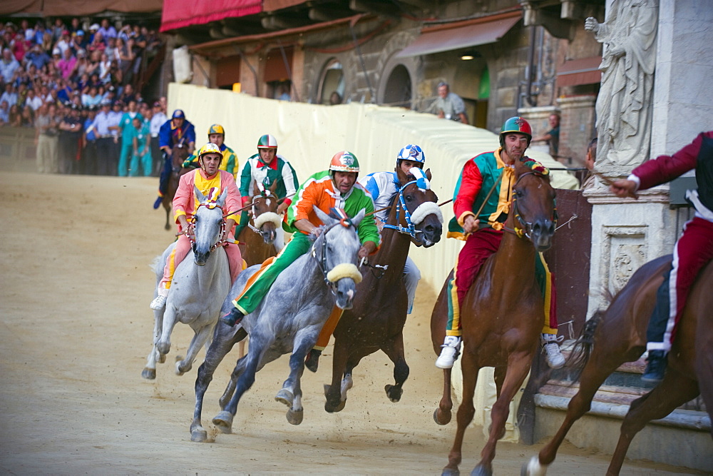 Riders racing at El Palio horse race festival, Piazza del Campo, Siena, Tuscany, Italy, Europe