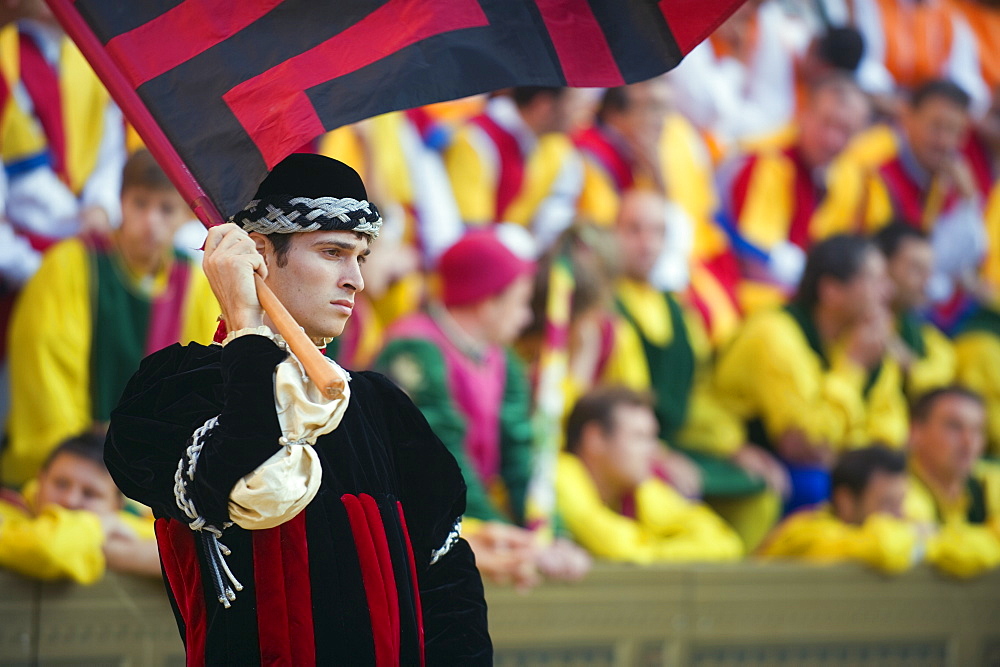 Flag bearer in parade at El Palio horse race festival, Piazza del Campo, Siena, Tuscany, Italy, Europe